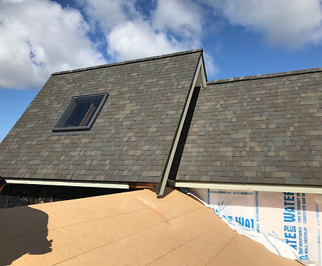 Repaired roof with new flashings against a clear sky